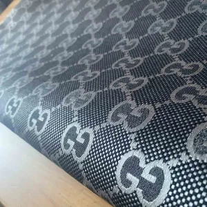 gucci jacquard fabric which has shiny and bigger patterns. gucci logo of patterns is like metallic gray and navy combination